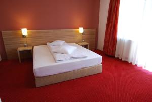 a bedroom with a white bed with two lamps on it at Vila Amira Predeal in Predeal +26 photos