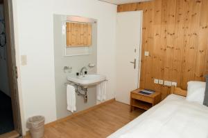 a small bathroom with a sink and a bed at Chamanna Bed & Breakfast in Arosa +101 photos