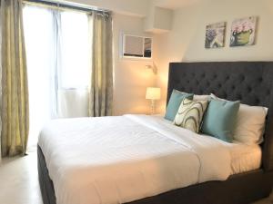 Un dormitorio con una cama grande y una ventana en One Bedroom Apartment at Sundance Residences with Hi-Speed WiFi en Cebú