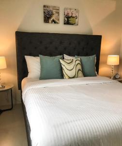una camera da letto con un grande letto bianco con due lampade di One Bedroom Apartment at Sundance Residences with Hi-Speed WiFi a Cebu City