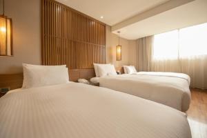 Voodi või voodid majutusasutuse Guide Hotel Taipei Bade toas