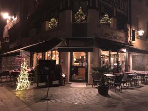 un restaurante con luces de Navidad, mesas y sillas en Les Initiés, en Rouen