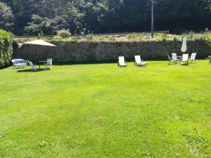 a group of lawn chairs and an umbrella in a yard at Apartamento Sopiedra in Nueva de Llanes