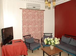 a living room with chairs and a tv and a wall at Philae Hotel Aswan in Aswan