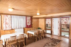 a dining room with tables and chairs and windows at Szyszka in Bukowina Tatrzańska
