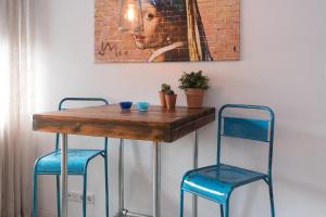a table with two blue chairs and a painting at Emperor Studio in Amsterdam