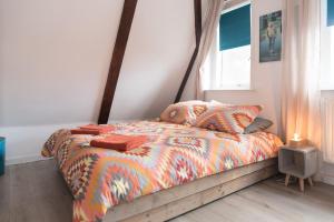 a bedroom with a bed with a comforter and a window at Emperor Studio in Amsterdam