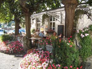 a group of people sitting at a restaurant with flowers at Royal Hotel-Restaurant Bonhomme in Sougné-Remouchamps