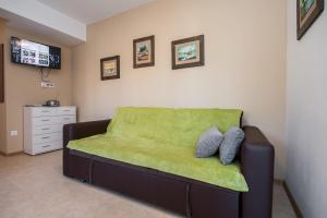 ein Wohnzimmer mit einem Sofa und einer grünen Decke in der Unterkunft Villa Second-Home in Ražanj