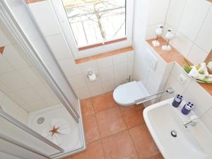 ein Bad mit einem Waschbecken, einem WC und einem Fenster in der Unterkunft Haus Möwe - Apt. 013 in Ostseebad Sellin