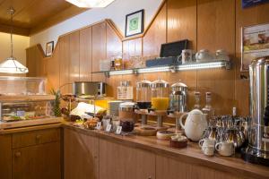 eine Küche mit einer Theke mit vielen Gegenständen darauf in der Unterkunft Pension Brixana in Brixen im Thale
