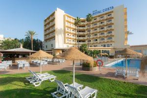 Royal Costa في توريمولينوس: فندق فيه كراسي ومظلات بجانب مسبح