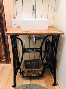 a bathroom sink on a table with a basket under it at Akurgerði Guesthouse 4 - Country Life Style in Ölfus