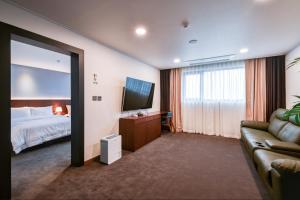 pokój hotelowy z łóżkiem i kanapą w obiekcie Sea Moon Tourist Hotel w mieście Inczon
