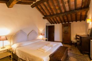 una camera da letto con un grande letto bianco e un soffitto in legno di Casa Marina a Greve in Chianti