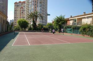 two people playing tennis on a tennis court at Rinconada Real Bungalows- Ap2000 in Benidorm