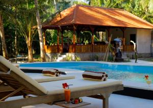 einen Resortpool mit einem Tisch und einem Pavillon in der Unterkunft Crystal Bay Villa & Residence in Nusa Penida
