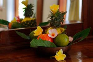 a bowl of fruit with flowers and pears on a table at Crystal Bay Villa in Nusa Penida