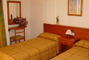 a hotel room with two beds and a mirror at Rinconada Real Bungalows- Ap2000 in Benidorm