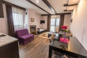a living room with purple furniture and a fireplace at Divčibarski Vajati in Divčibare