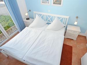 Schlafzimmer mit einem Bett mit weißer Bettwäsche und einem Fenster in der Unterkunft Haus Möwe - Apt. 013 in Ostseebad Sellin