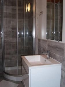 La salle de bains est pourvue d'un lavabo et d'une douche. dans l'établissement chez Andréa, à Le Mont-Dore