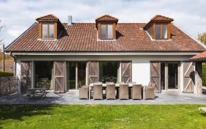 a house with a group of chairs in front of it at Le Coeur des Choses in Escalles
