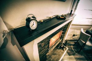 an alarm clock sitting on top of a fireplace at Divčibarski Vajati in Divčibare