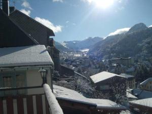 a view of a town with snow covered mountains at chez Andréa in Le Mont-Dore