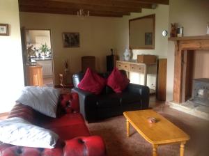 a living room with a black couch and a table at La Croix Saint Gilles in Langourla