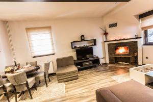 a living room with a fireplace and a table and chairs at Divčibarski Vajati in Divčibare