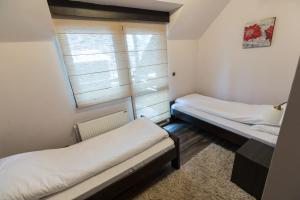 two beds in a small room with a window at Divčibarski Vajati in Divčibare