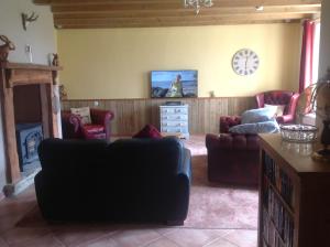 a living room with a couch and a tv at La Croix Saint Gilles in Langourla