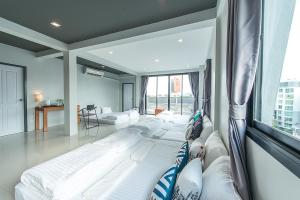 Habitación con 3 camas grandes y ventana. en Sleep Station en Surat Thani