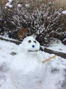 un muñeco de nieve sentado en la nieve en un patio en Casa la Devesa de Sanabria, en Remesal