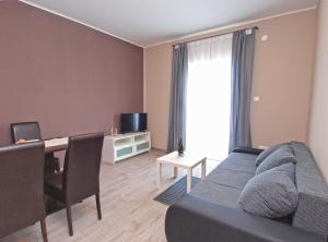 een woonkamer met een bank, een tafel en een televisie bij Luna in Pula