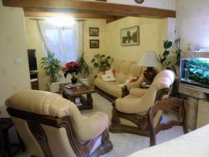 a living room with couches and a flat screen tv at Chambres d'Hotes Le Pavillon du Charme in Cousances-aux-Forges
