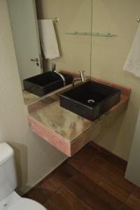 a bathroom with a black sink and a mirror at Hotel Pedra Moura in Vacaria