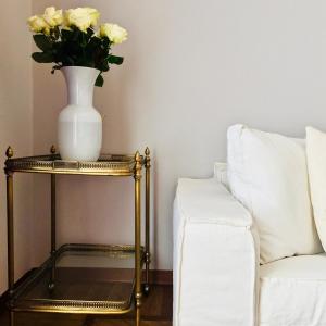 um vaso de flores numa mesa ao lado de um sofá em Dimora Mantelli em Mestre