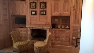 a living room with two chairs and a fireplace at Grancia dei Celestini in Sulmona