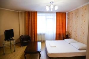 1 dormitorio con cama, mesa y ventana en квартира на Торосова, en Abakán