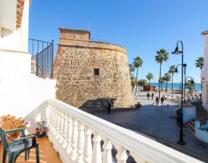 kamienna wieża ze schodami obok budynku w obiekcie Casa playa el Torreon w mieście La Cala de Mijas