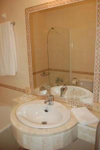 a bathroom with a sink and a mirror at Hotel Jardim in Elvas