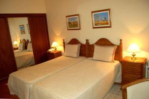 a bedroom with two beds and two lamps at Hotel Jardim in Elvas