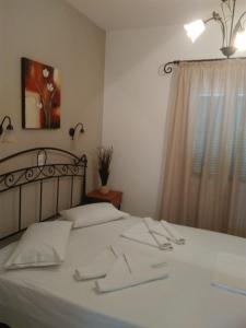 a bedroom with a bed with white sheets and a window at Magic Land in Plaka