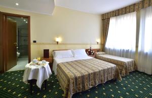 a hotel room with two beds and a table at Dropiluc in Druento +11 photos