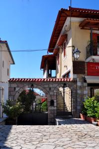 a building with a gate and a stone driveway at Guesthouse Doma in Arachova