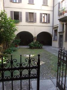 une porte devant un bâtiment avec des arches dans l'établissement La stufa rossa, à Sondrio