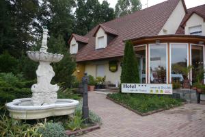 a large stone fountain in front of a house at Hotel Sud Alsace in Ranspach-le-Bas