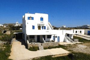 a white house with a blue roof and white walls at Villa Vasilis in Mikonos